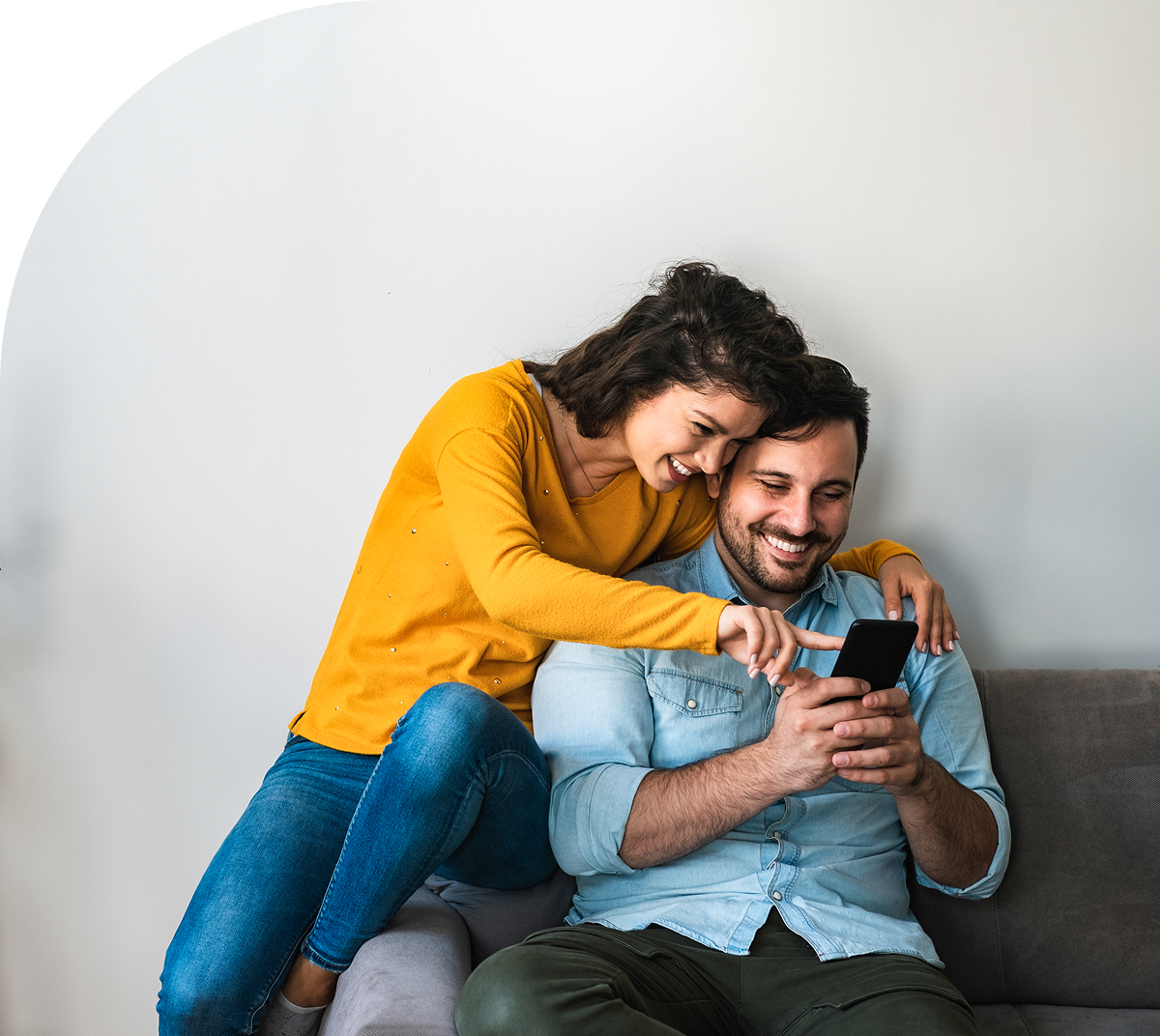 Couple smiling while looking at phone