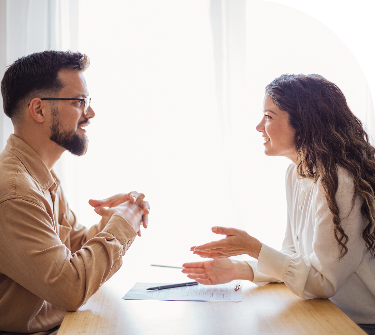 Man and woman having a conversation indoors.