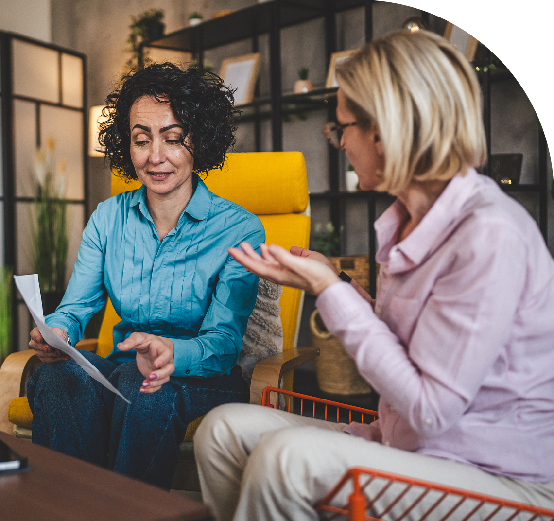 Two women discussing a document together.